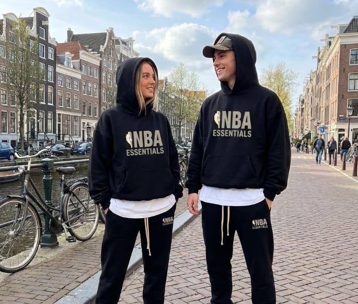 Black Fear of God Essentials x NBA hoodie with logo detail, casual fit, and soft fabric from THE EA STORE.