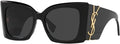 Saint Laurent oversized sunglasses with a glossy black frame, dark lenses, and a gold-tone YSL logo on the temple arm.