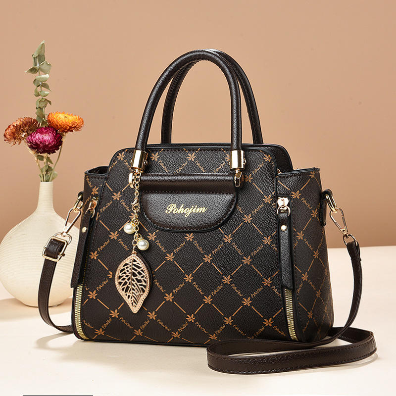 Black handbag with gold accents on a beige background