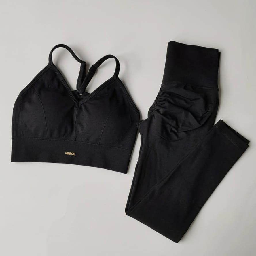 Black sports bra and leggings set on a light gray background