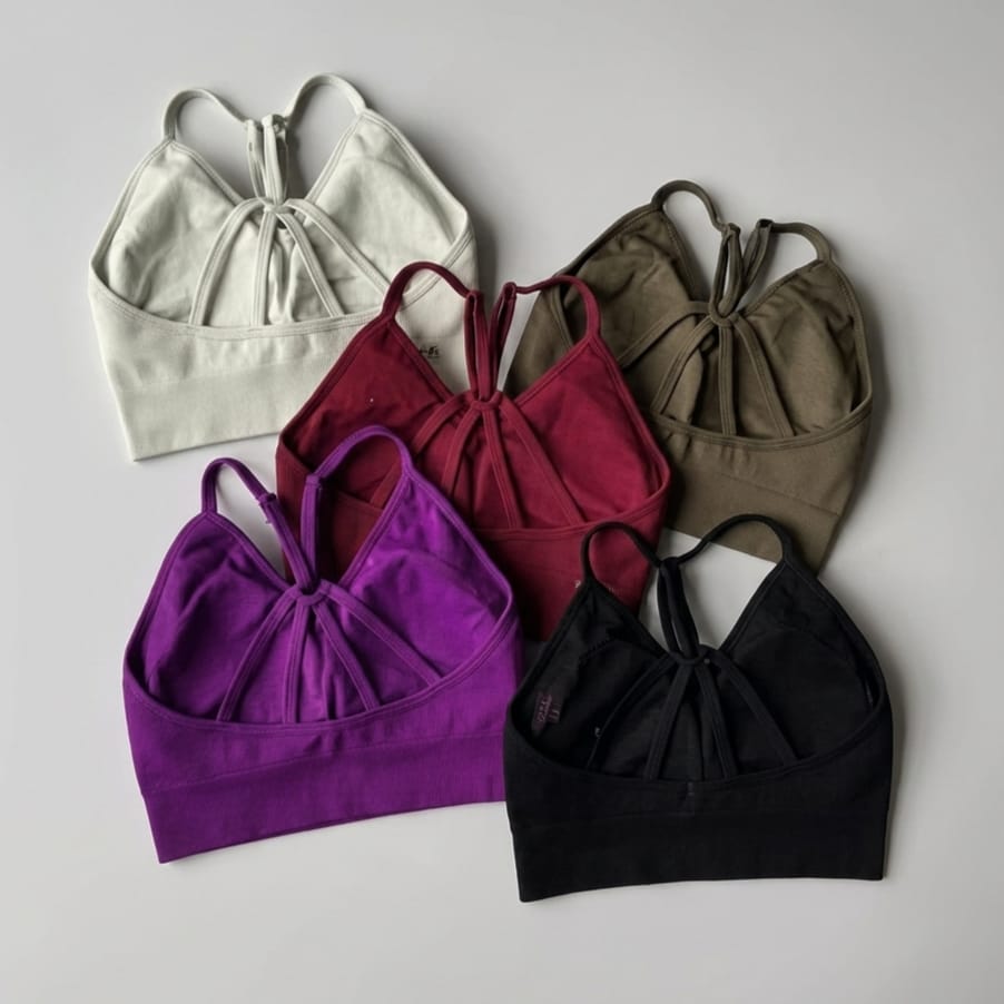 Five crop tops in different colors on a gray background