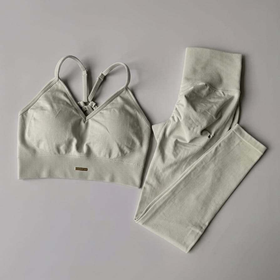 Light green sports bra and leggings set on a gray background