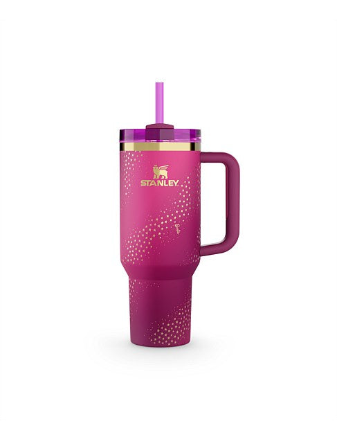 Pink Stanley tumbler with a straw on a white background