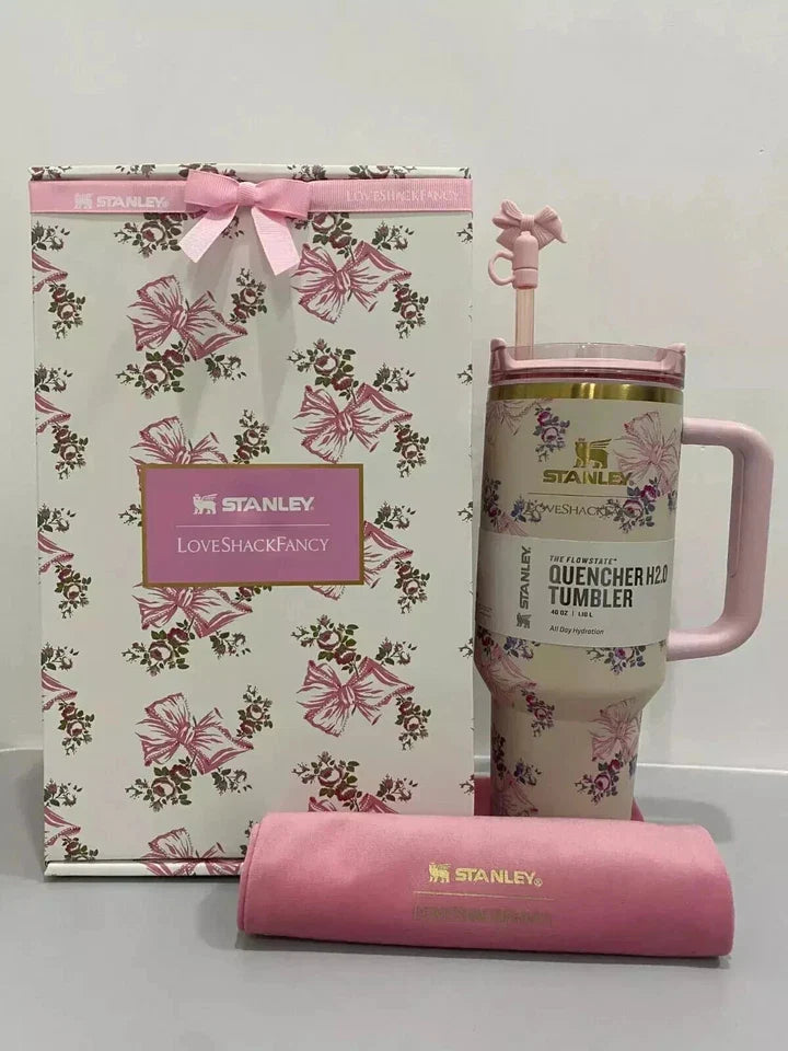 Pink floral Stanley tumbler with matching gift bag and sleeve on a white background