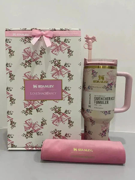Pink floral Stanley tumbler with matching gift bag and sleeve on a white background