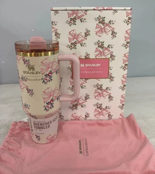 Pink floral Stanley tumbler with matching pouch and floral-patterned box on a gray background