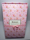 Pink floral notebook with a brand name on a white background