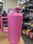 Pink water bottle with a straw on a white background