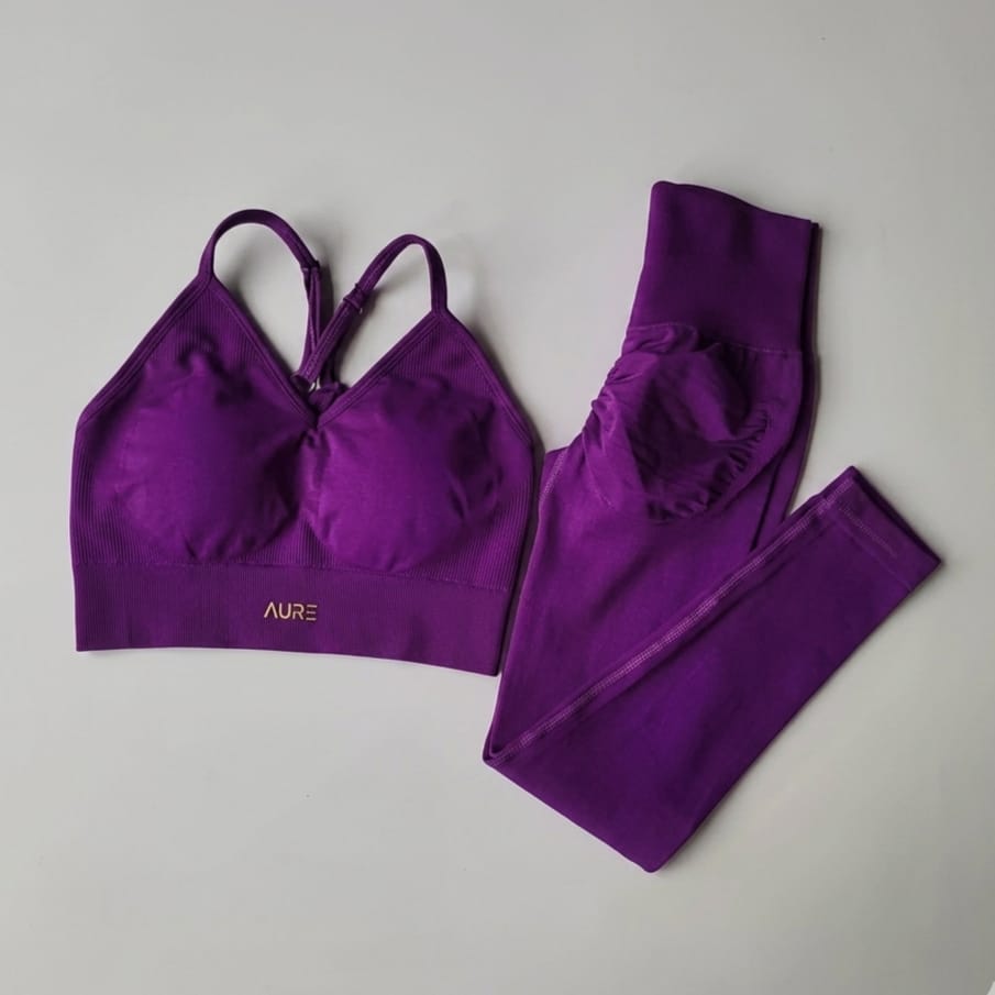 Purple sports bra and leggings set on a gray background
