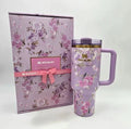 Floral-patterned Stanley mug and packaging on a white background