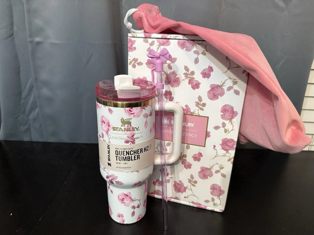 Stanley tumbler with floral design and matching box on a dark surface