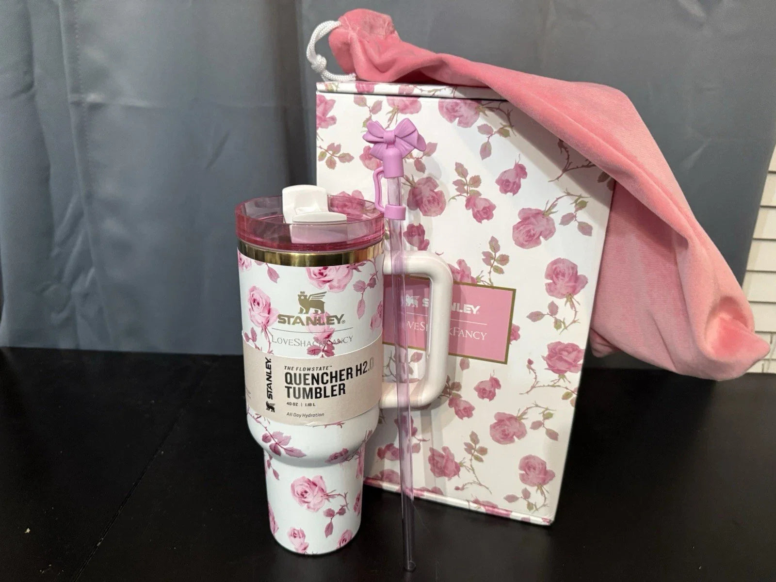 Stanley tumbler with floral design and matching box on a dark surface