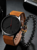 Wristwatch with brown leather strap and black beaded bracelet on a dark surface
