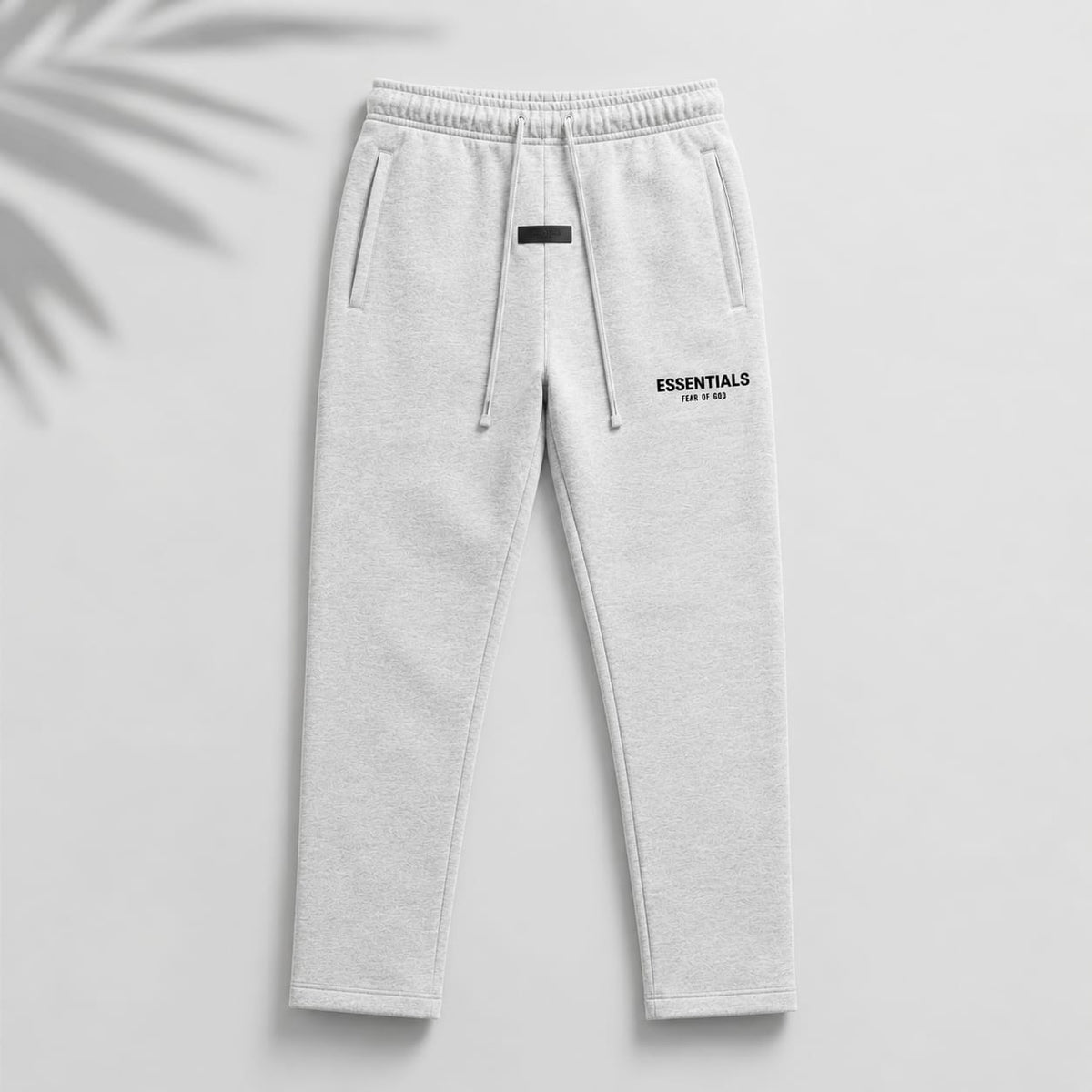 Light oatmeal Fear of God Essentials relaxed sweatpants from THE EA STORE, showing the comfortable fit and soft fabric.